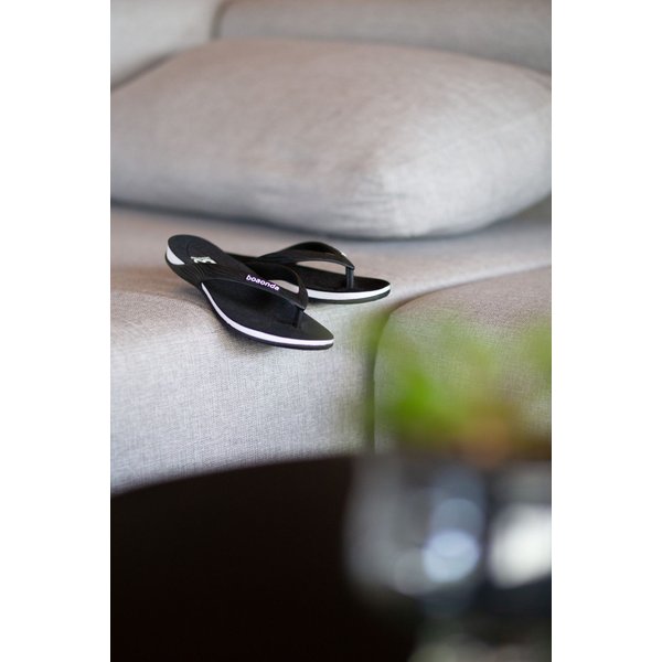 Chinelo Happy preto no sofá